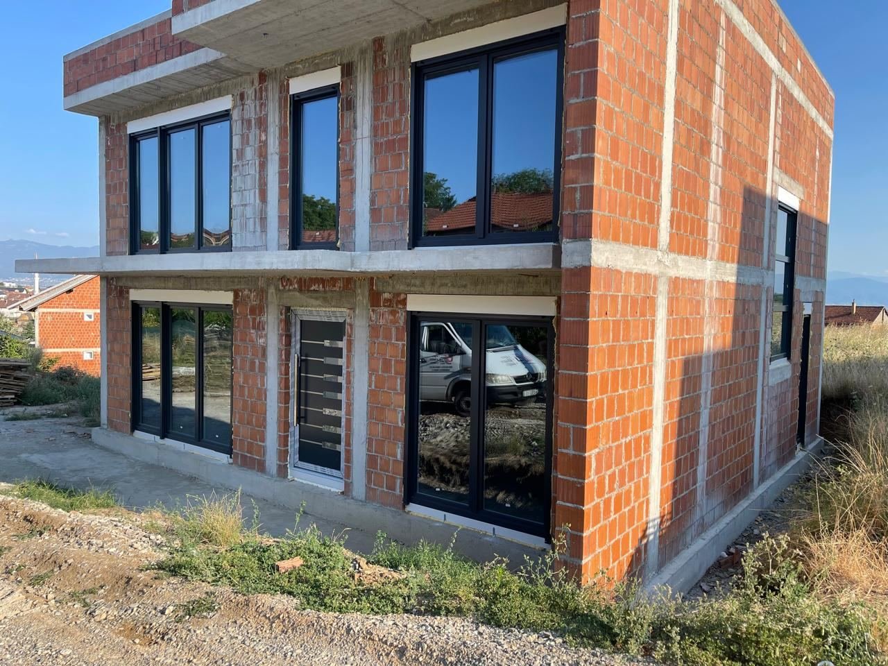 Dritare PVC antracit të montuara në një shtëpi në ndërtim